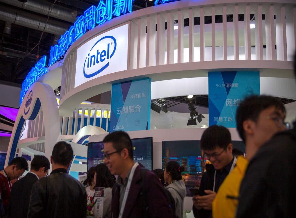 <p>File: Attendees walk past a booth from chipmaker Intel at the PT Expo in Beijing on Oct. 31, 2019</p>