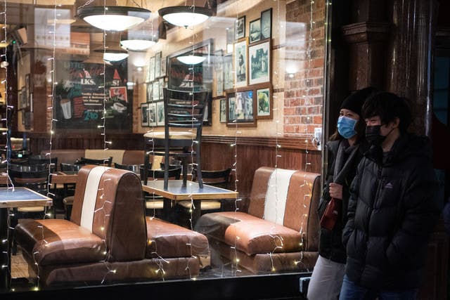 People pass a largely empty restaurant in central London (Dominic Lipinski/PA)