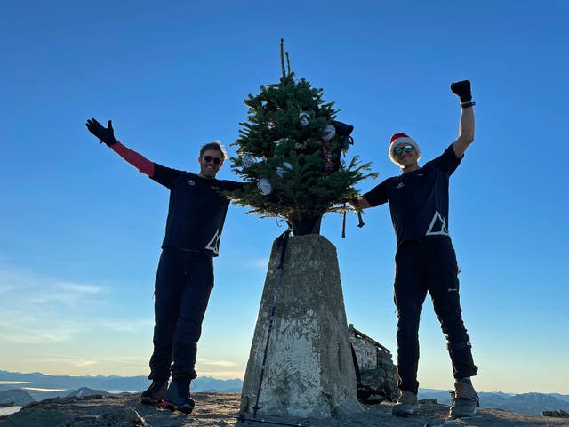 Ed Jackson (right) and Ross Stirling have successfully carried the tree to the summit of Ben Nevis during their 12 Peaks of Christmas challenge (Ed Jackson/PA)