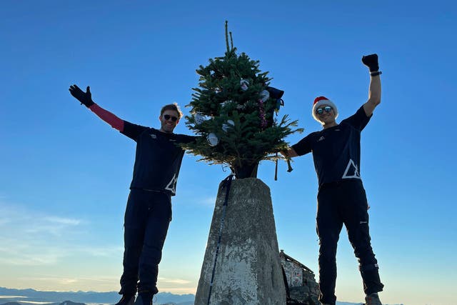 Ed Jackson (right) and Ross Stirling have successfully carried the tree to the summit of Ben Nevis during their 12 Peaks of Christmas challenge (Ed Jackson/PA)