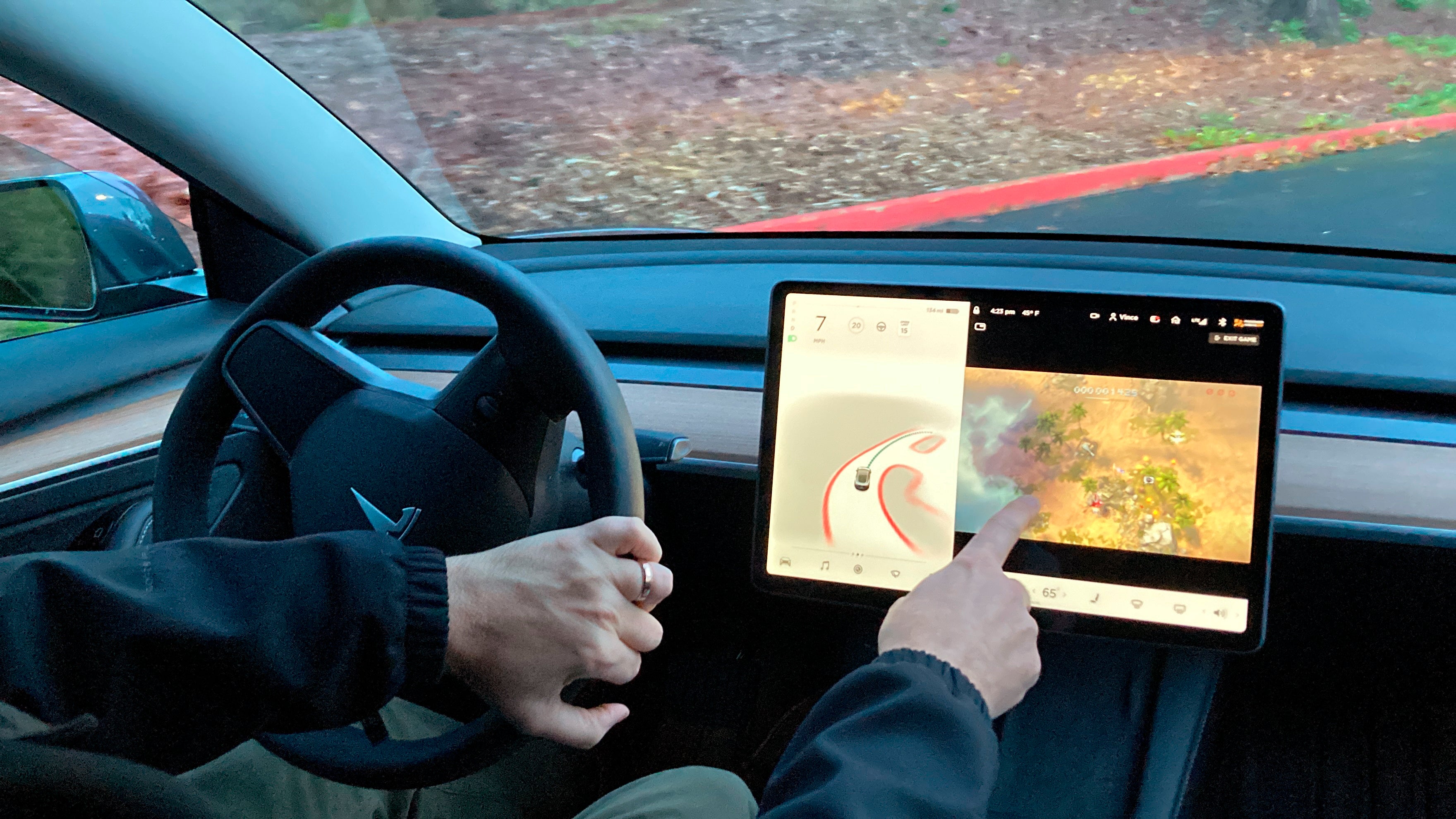 Vince Patton, a new Tesla owner, demonstrates how he can play video games on the vehicle’s console while driving