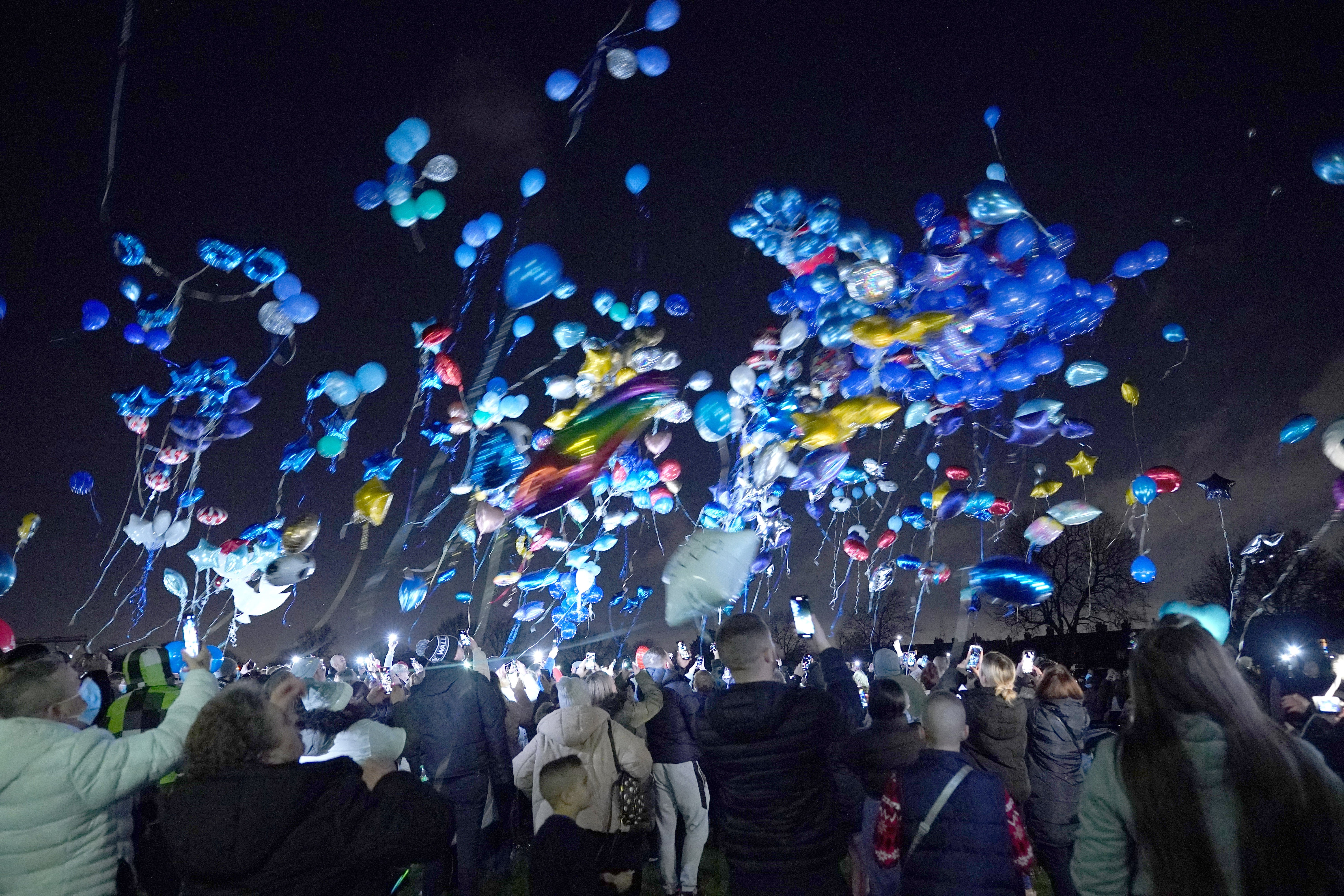 People release balloons in Sutton, in memory of the four brothers