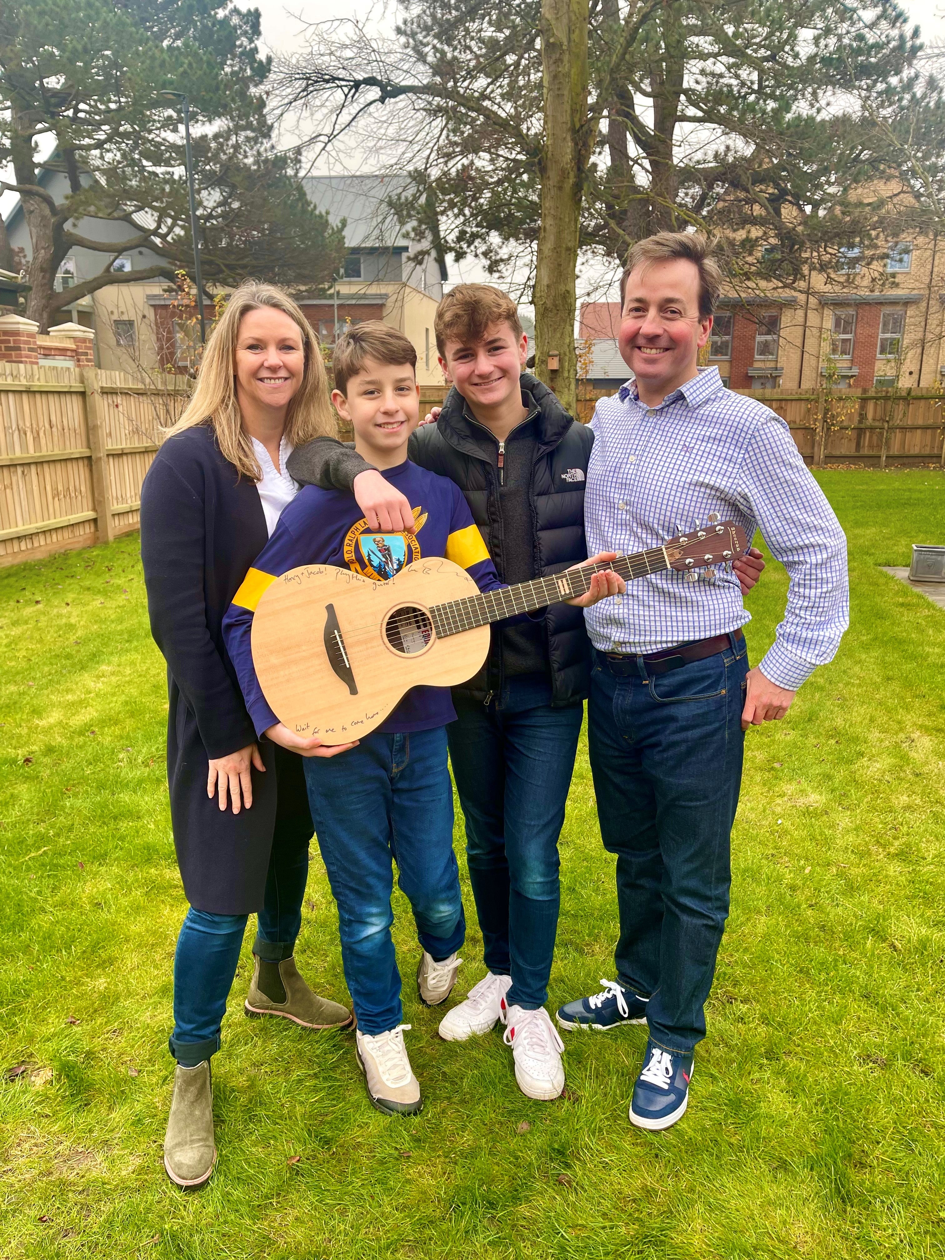 Hospital worker Kellie Myers and her family with Ed Sheeran’s prototype guitar, that they won through a charity raffle. (GeeWizz/ PA)