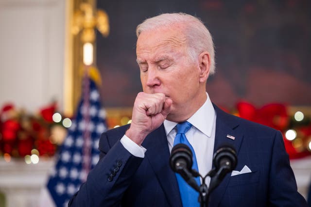 <p>US president Joe Biden coughs while speaking on the Covid pandemic in the State Dining Room of the White House in Washington</p>