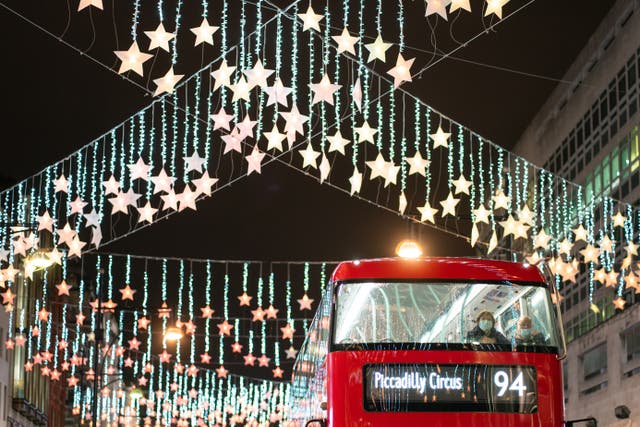 Passengers on a bus travel under Christmas lights on Oxford Street in central London (Dominic Lipinski/PA)