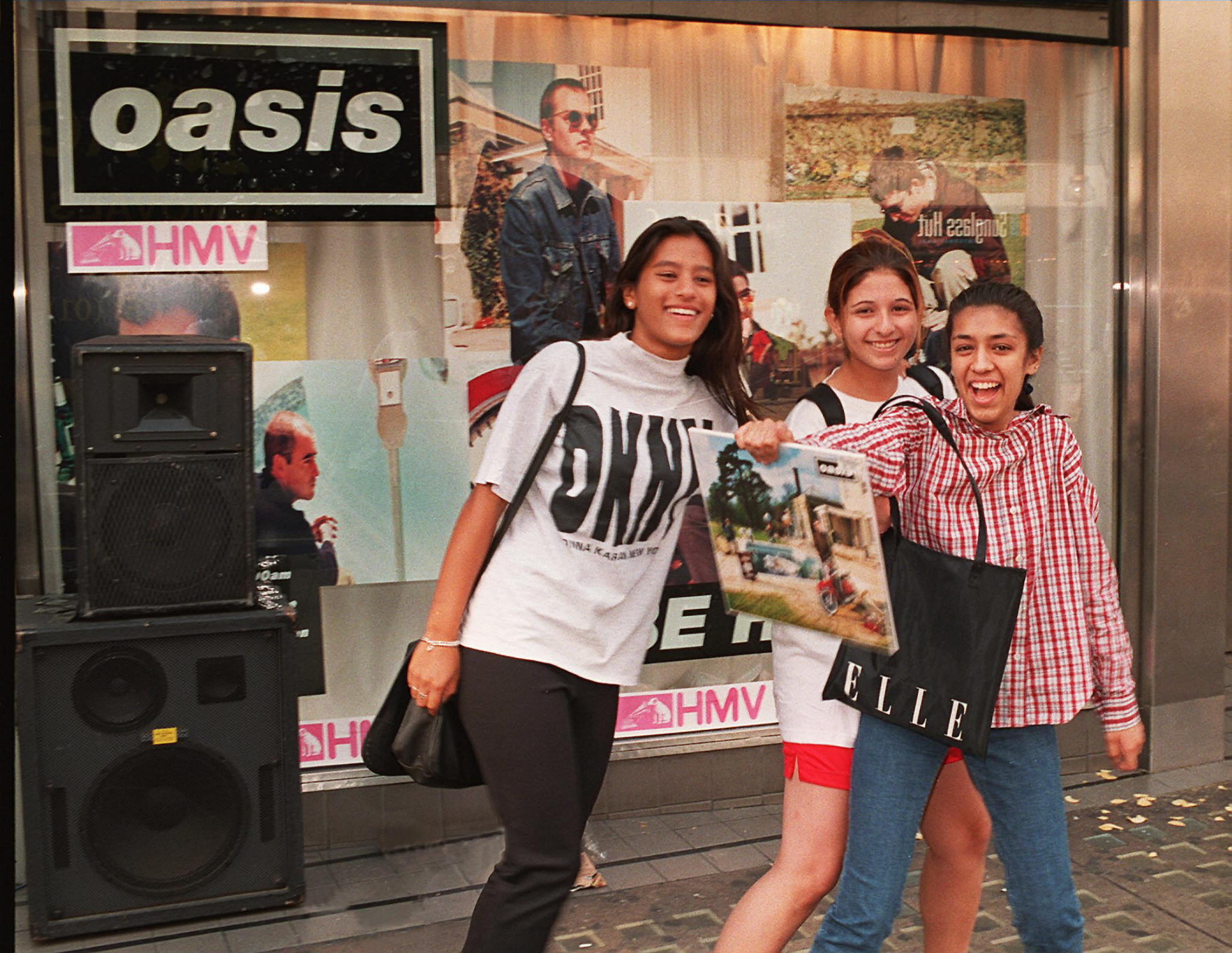 Oasis fans show off the band’s new album ‘Be Here Now’, in front of HMV’s poster-covered window in London’s Oxford Street, in August 1997