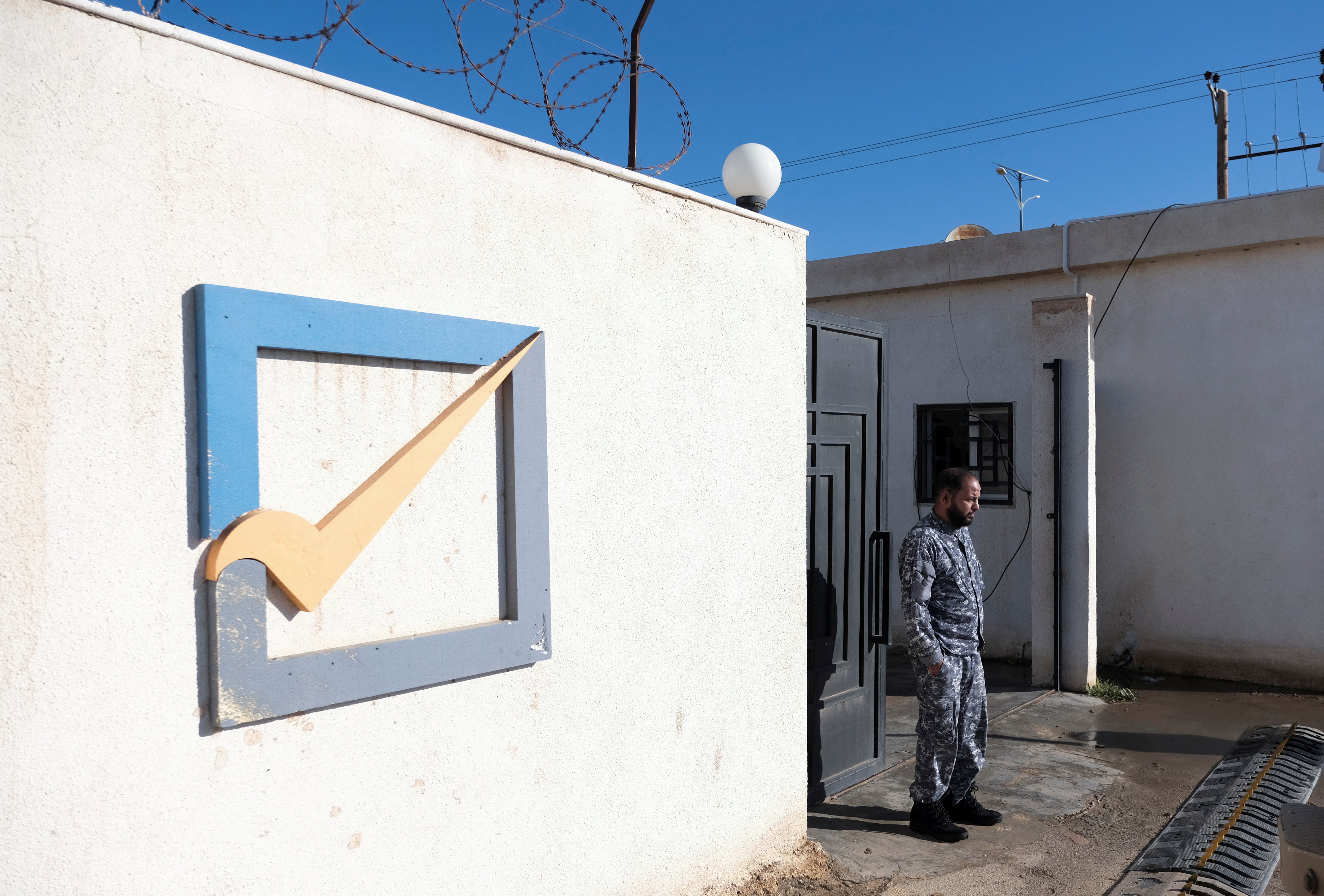 A member of security stands in front of the High National Election Commission building in Benghazi, Libya, 24 December 2021