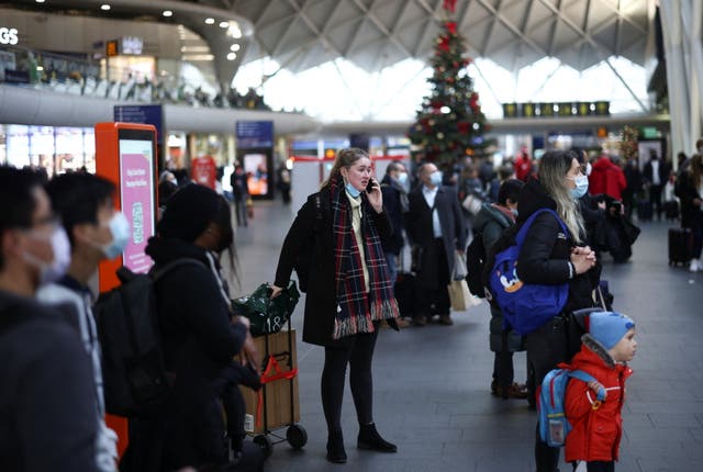 People stand inside Kings Cross Station on Christmas Eve in London