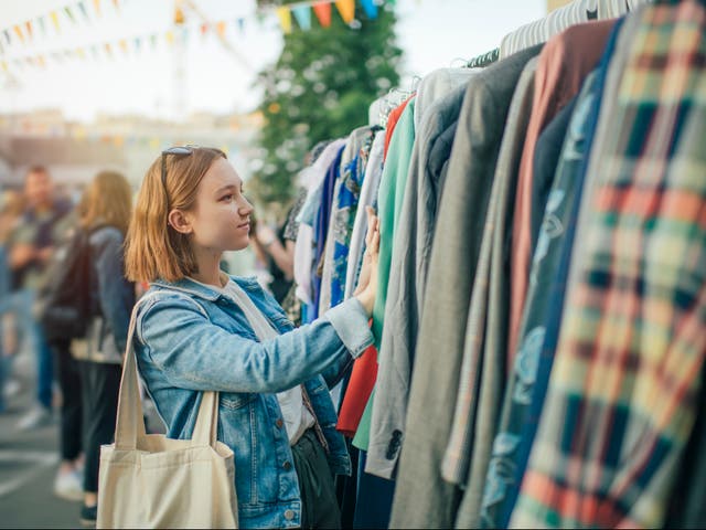 <p>A young woman shops at a second-hand market</p>