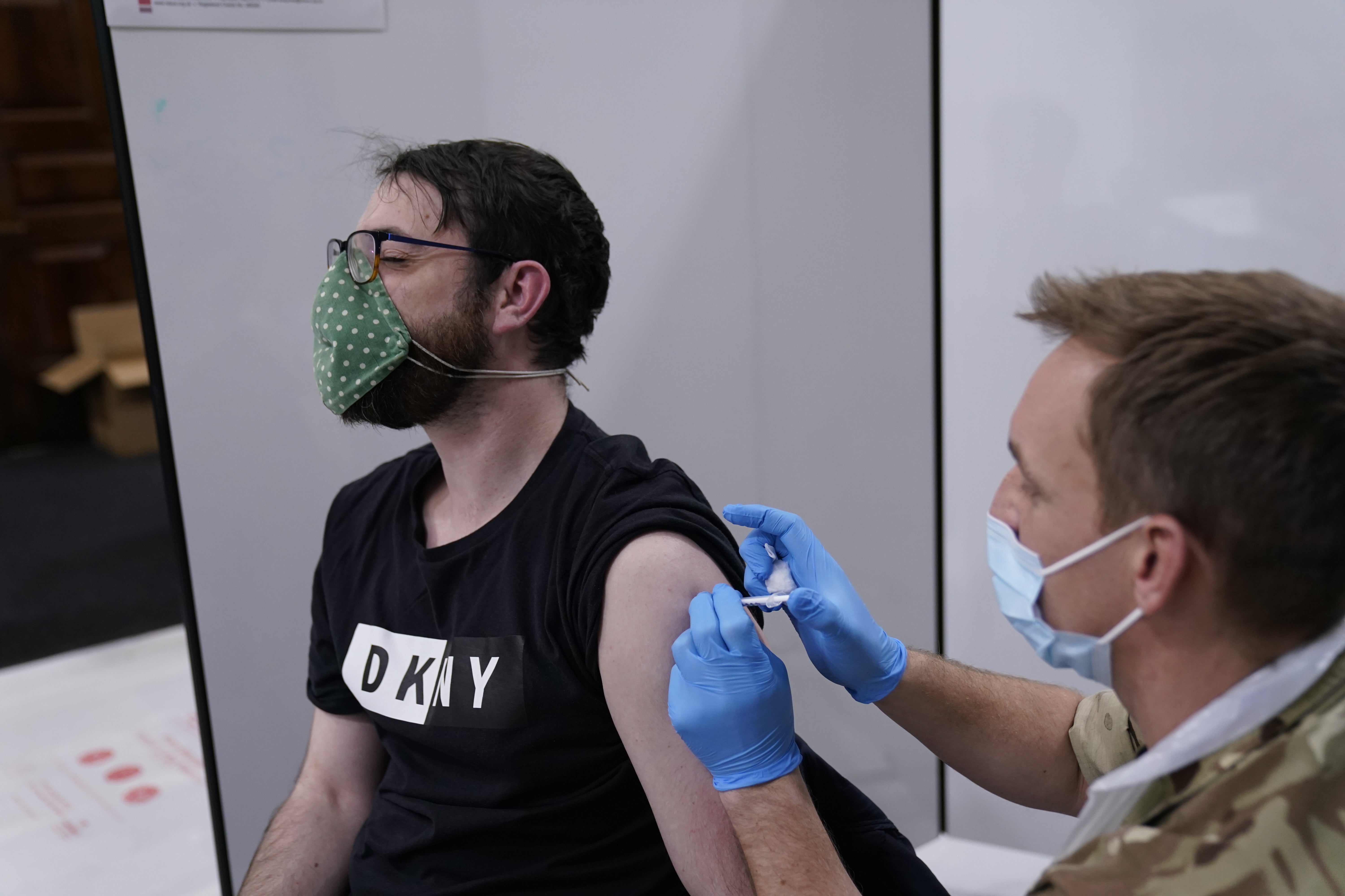 Bomdardier Ian Bloomfield of the 5th Regiment Royal Artillery administers a vaccine at the Covid vaccination centre in Rates Hall Manchester (Danny Lawson/PA)