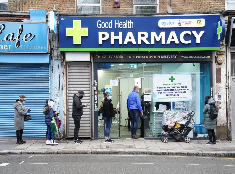 People wait in line to receive a ‘Jingle Jab’ Covid vaccination booster injection at the Good Health Pharmacy, north London (Gareth Fuller/PA)