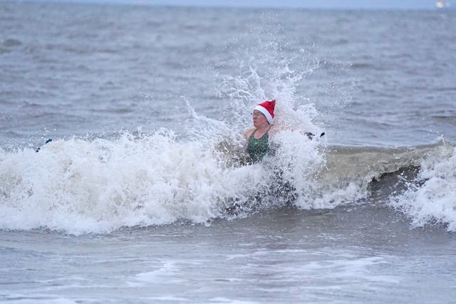 Swimmers take a Christmas Day dip at Portobello Beach in Edinburgh (Andrew Milligan/PA)