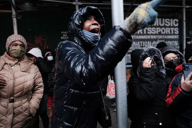 <p>People form a large crowd as they attempt to receive COVID-19 testing kits from city workers distributing the kits along Flatbush Avenue on Christmas Eve</p>