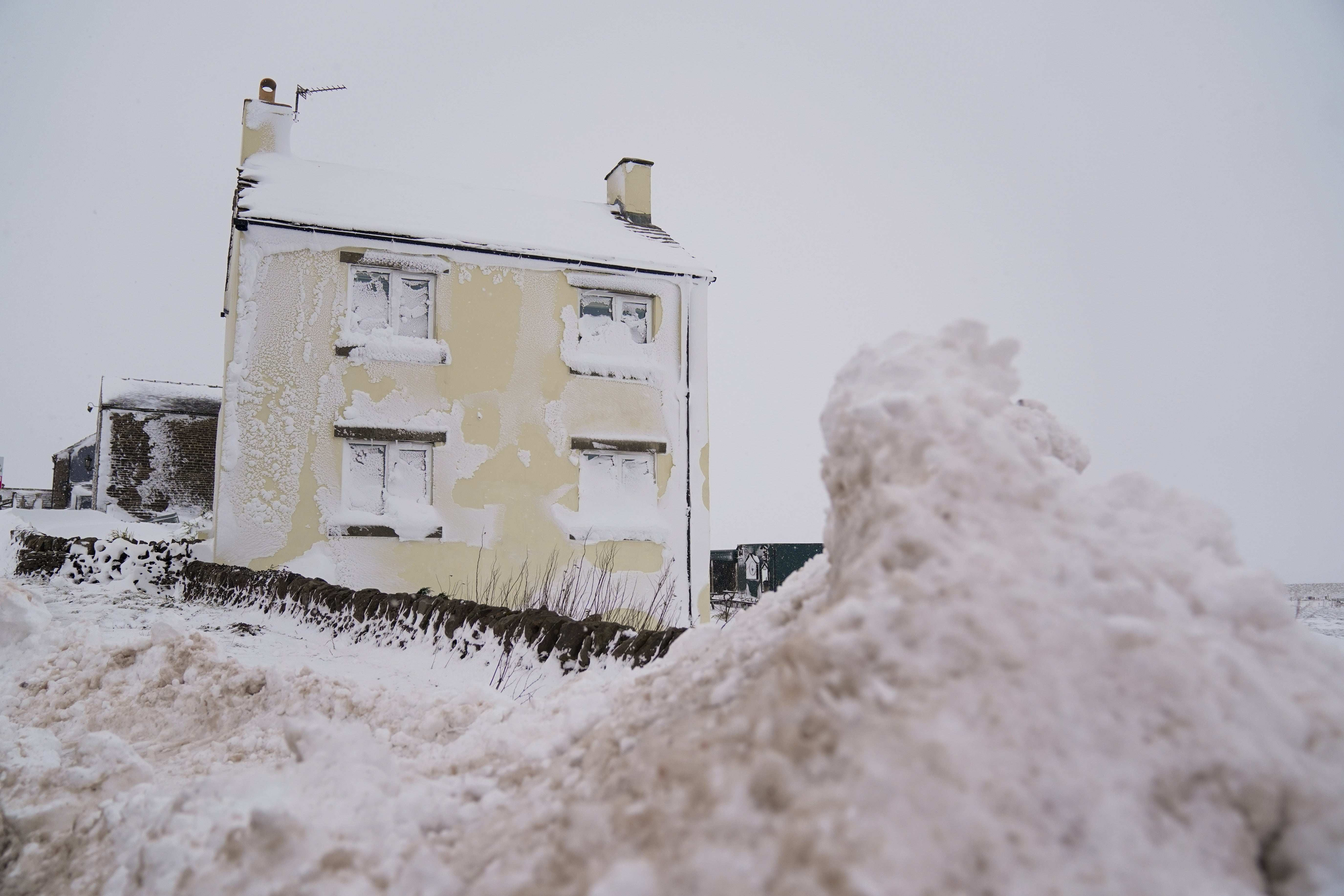 A house is covered in snow on the A53 close to Buxton (Jacob King/PA)