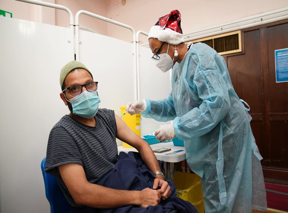 <p>A man receives a 'Jingle Jab' Covid vaccination booster injection at Redbridge Town Hall, in Ilford, Essex, as the coronavirus booster programme continues across the UK on Christmas day.</p>