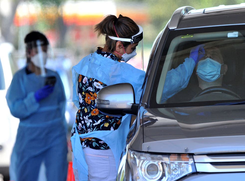 <p> medical worker takes a swab from a man at a drive-through Covid-19 test centre in western Sydney on December 21, 2021. </p>