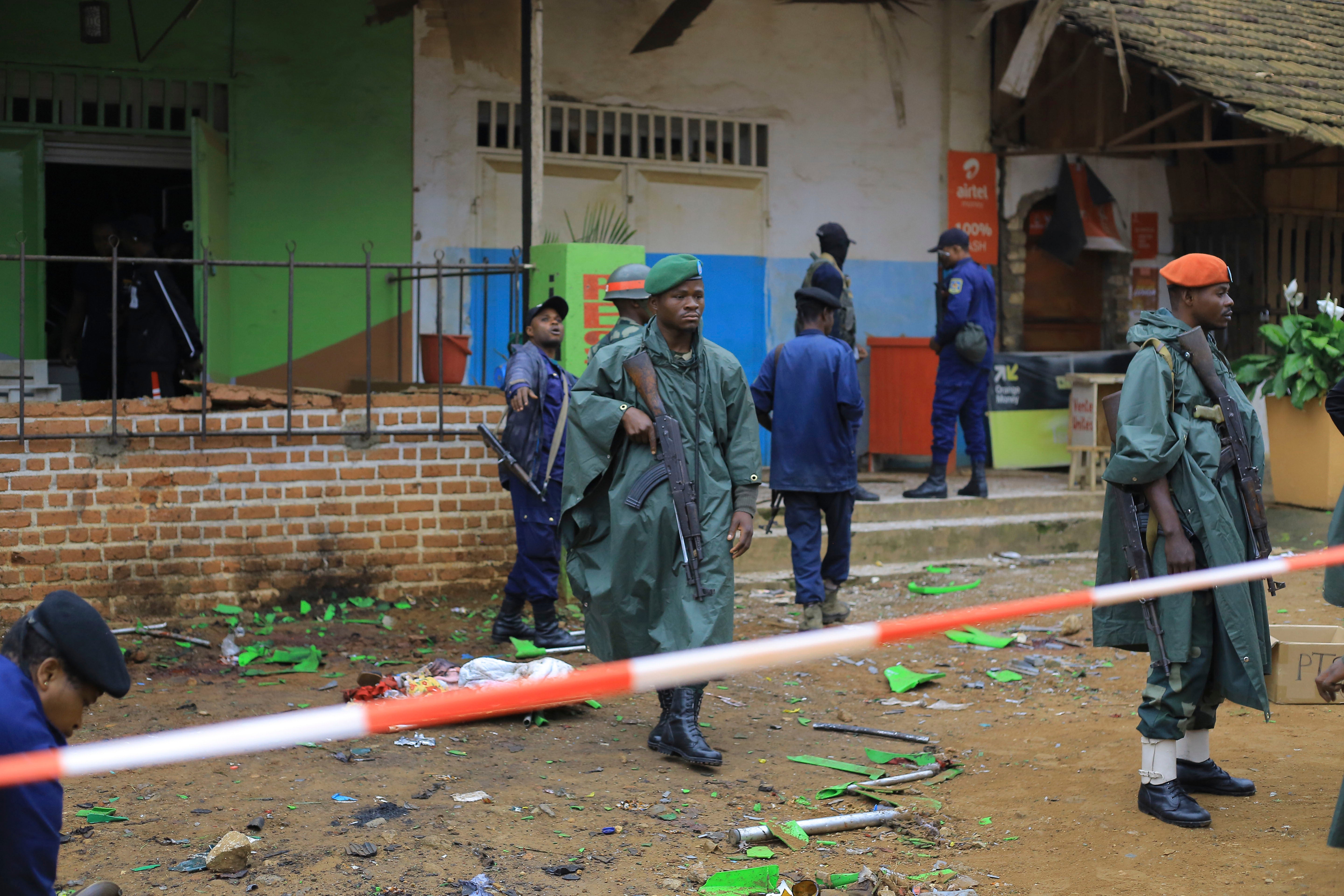 Police officers inspect the scene of a bomb explosion in Beni, eastern Congo, which left six dead