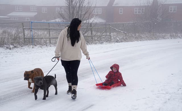A woman pulls a child through the snow on a sledge in Tow Law, County Durham. Parts of England from the East Midlands to the North-East have joined Scotland in preparing for blizzard-like conditions on Boxing Day as the white Christmas continues.