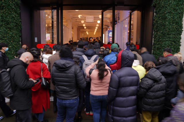 A crowd of shoppers stream through the entrance as doors open for the start of the Boxing Day sales at Selfridges department store on Oxford Street in London. Consumers are set to shop from home but spend more in the post-Christmas sales than in previous years in a reassuring sign for online retailers, a survey suggests (Jonathan Brady/PA)
