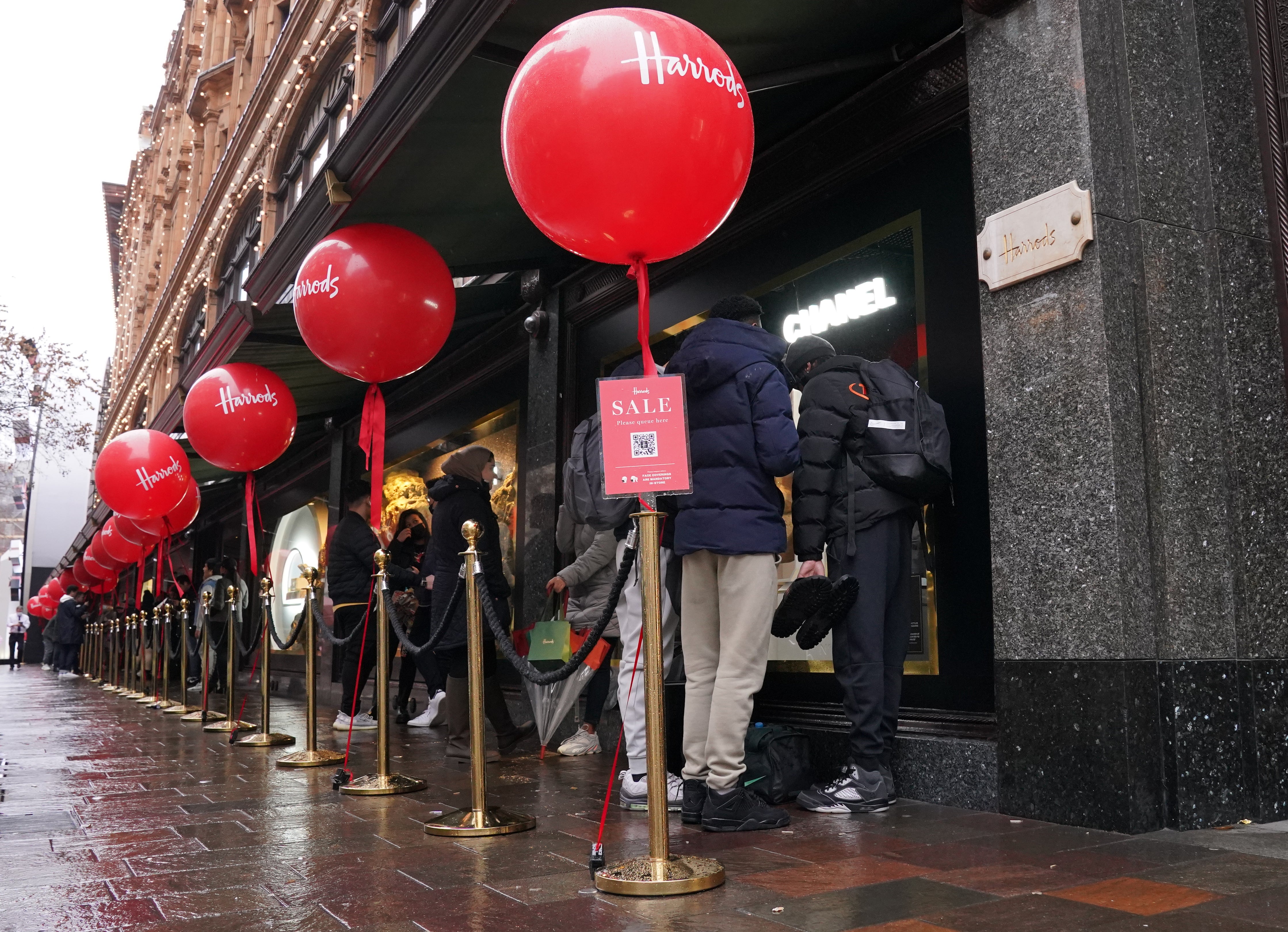 Customers begin to form a queue outside the Harrods store in Knightsbridge, London, waiting for the start the Boxing Day sales (Jonathan Brady/PA)