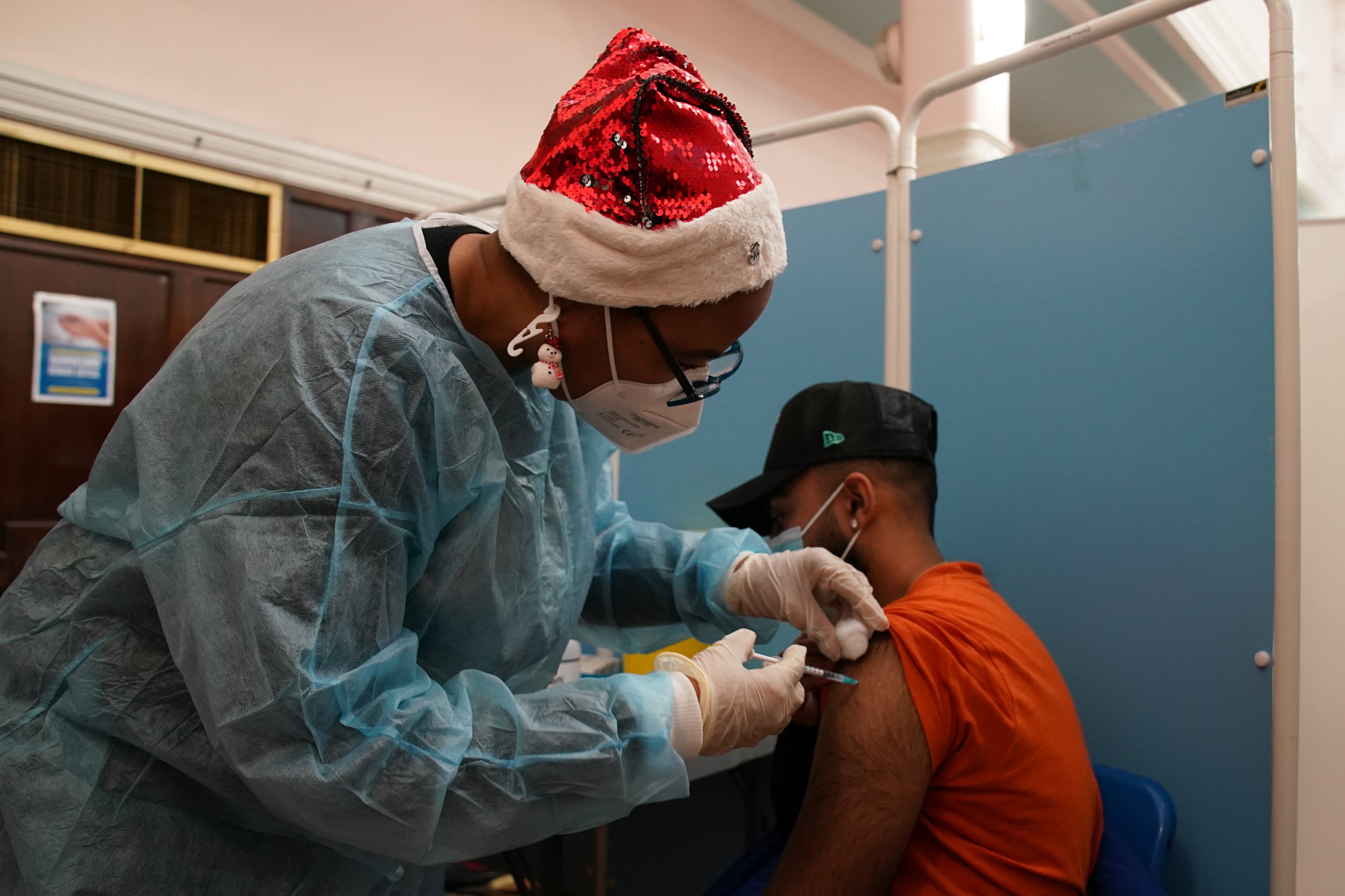 A vaccinator administers a ‘Jingle Jab’ Covid vaccination booster injection at Redbridge Town Hall, in Ilford, Essex, as the coronavirus booster programme continues (Gareth Fuller/PA)
