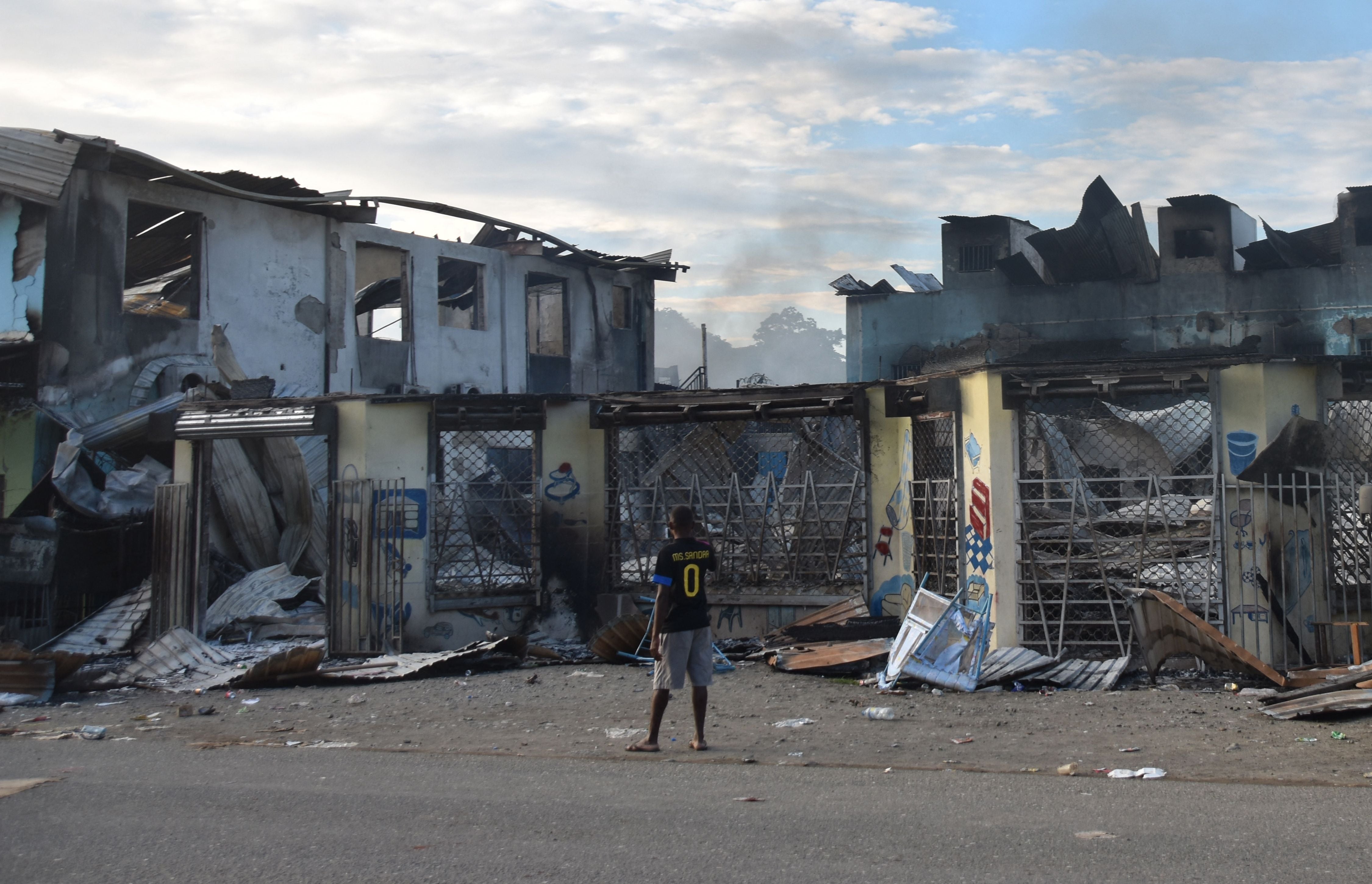 File photo: A man looks at damage caused by riots in Honiara, the Solomon Islands, 27 November 2021