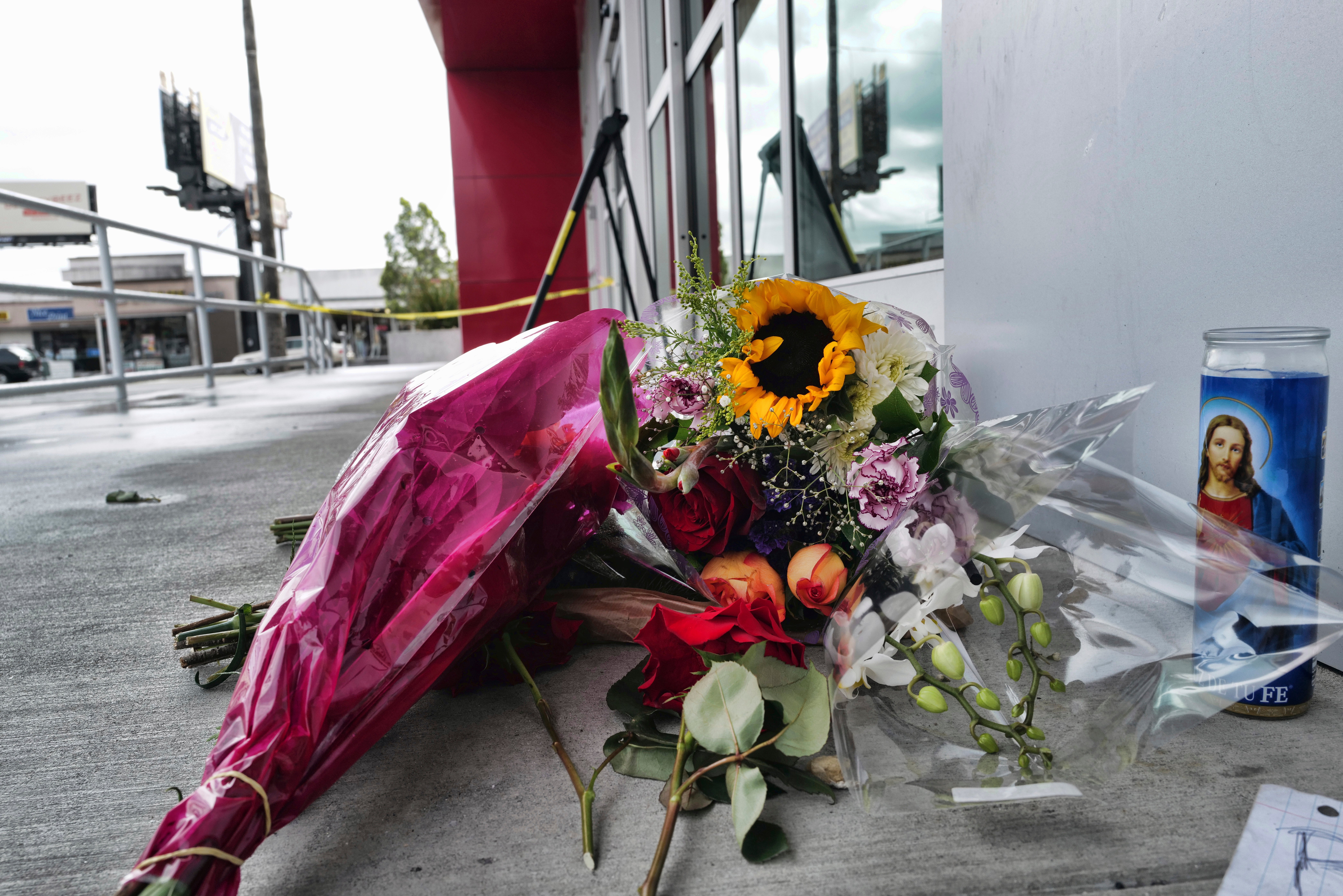 A votive candle and flowers are left for the teen who was fatally shot at a department store in North Hollywood section last week