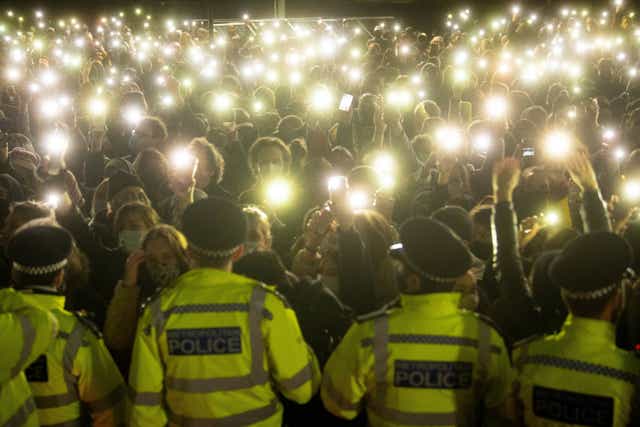 People turn on their phone torches as they gather in Clapham Common, London, for a vigil for Sarah Everard (PA)