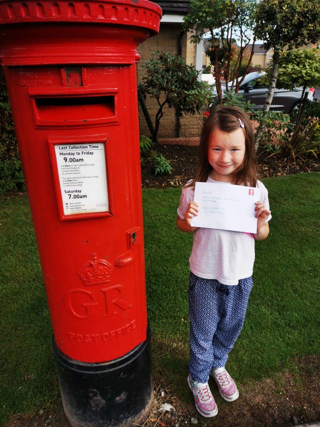 Cora Kelly Bell posting her letter to her grandmother Anne Kelly (Anne Kelly/PA)