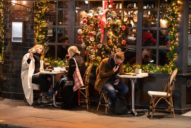 People eat outside a pub in central London (Dominic Lipinski/PA)