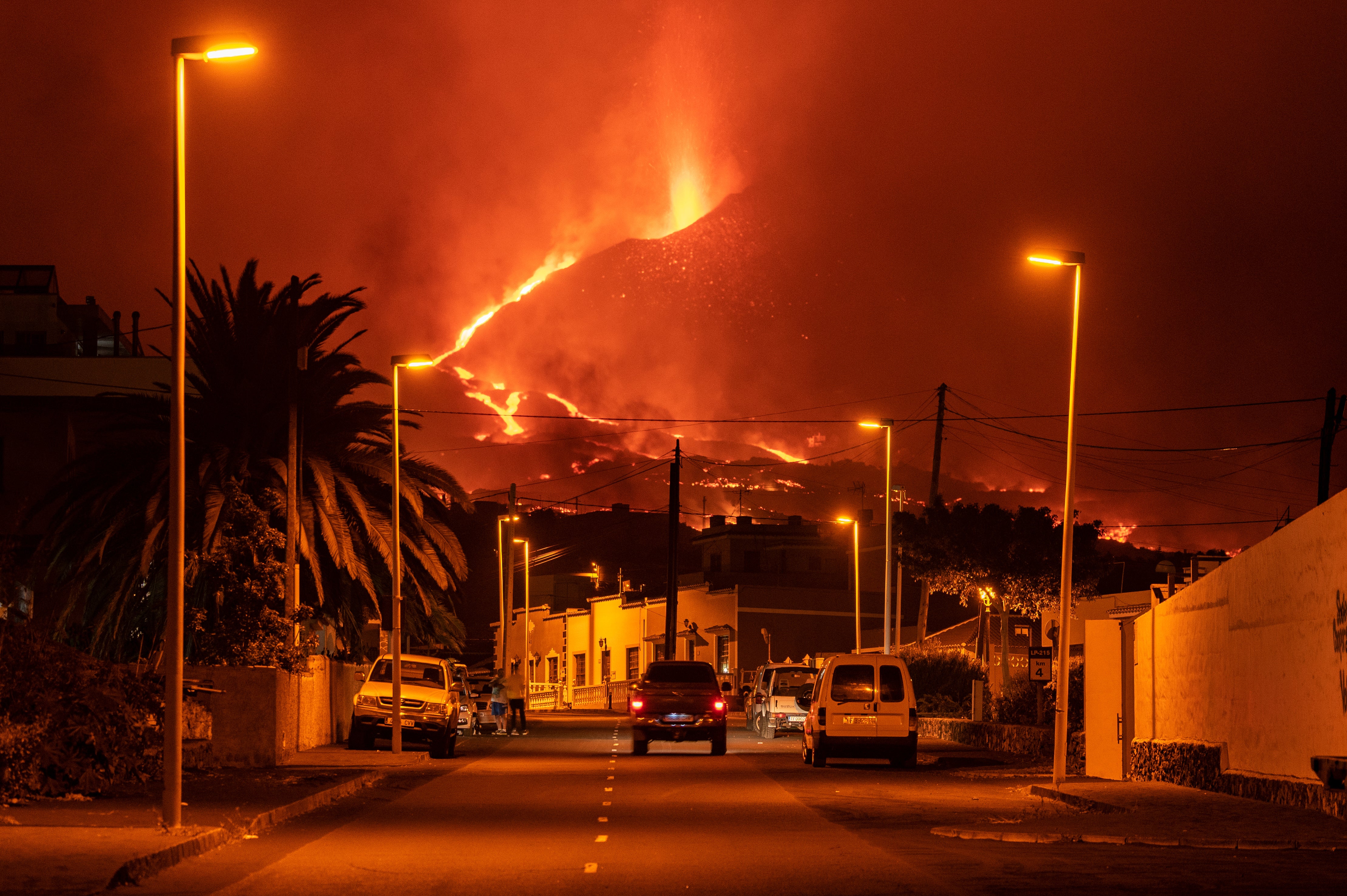 A car drives through an empty street in the neighborhood of La Laguna as lava flows from the Cumbre Vieja Volcano