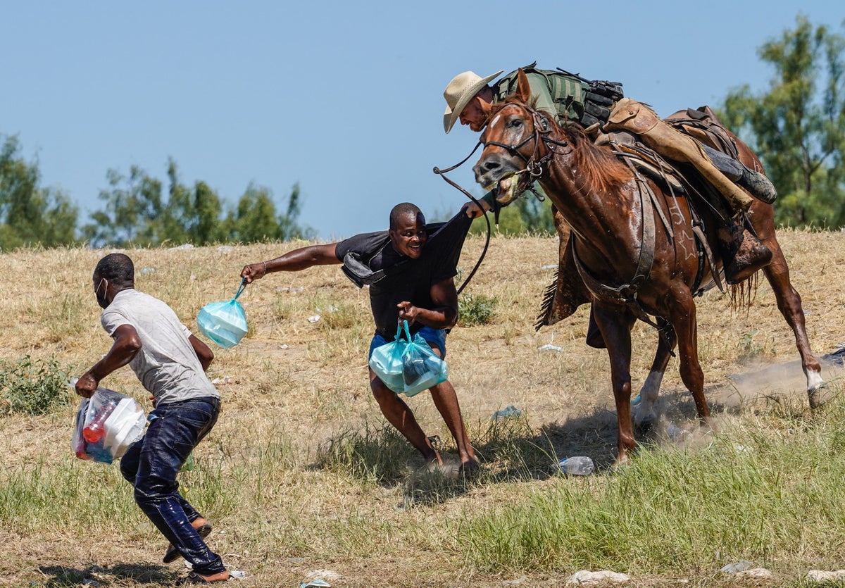 Image of Haitian refugee being chased by mounted border agent minted on memorial coin