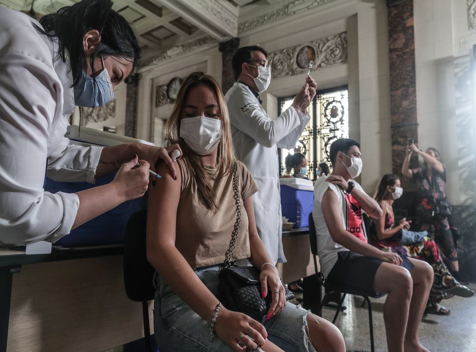 <p>A person receives a Covid vaccine in Rio de Janeiro, Brazil</p>
