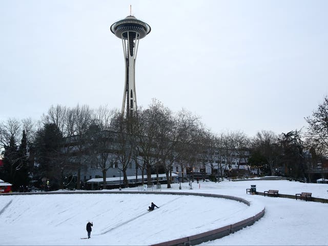 <p>A person uses a sled on the frozen International Fountain at Seattle Center, Seattle </p>