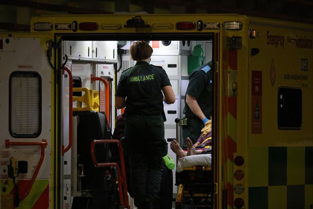 <p>An Ambulance crew bring a patient to the Royal London hospital in London on 28 December</p>