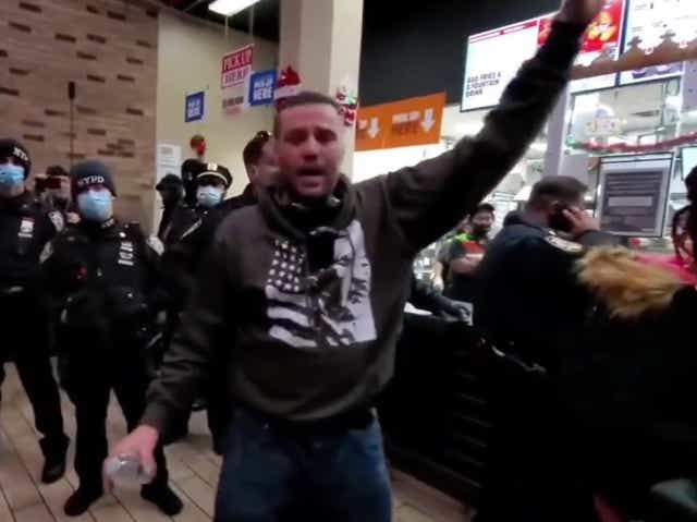 <p>A man speaking during an anti-vaccine protest at a Burger King on Monday </p>