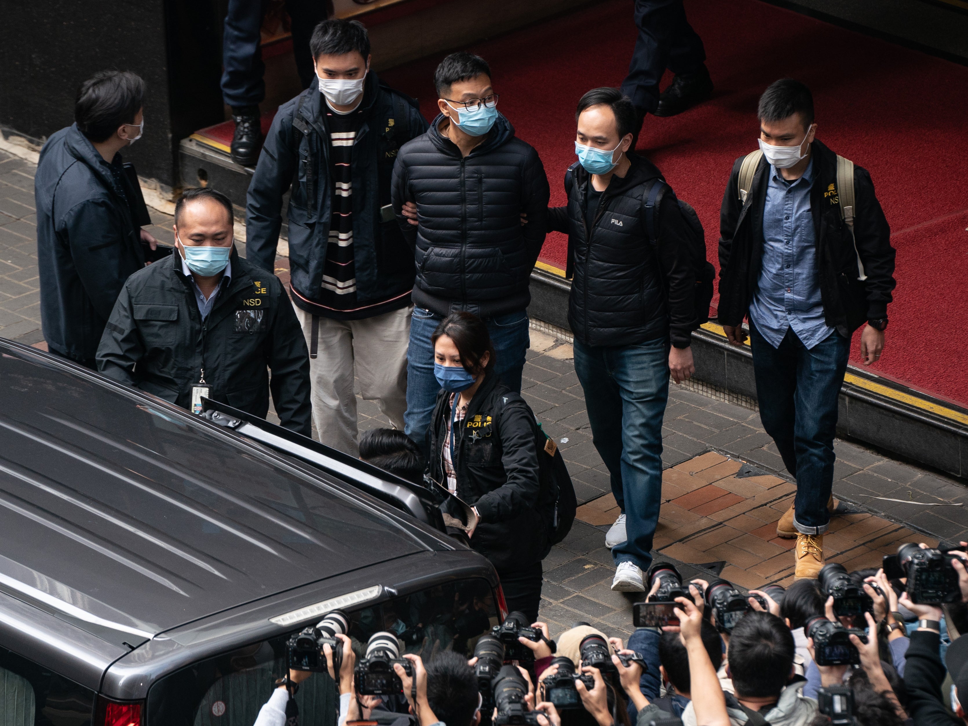 Stand News Editor-in-Chief Patrick Lam is brought to a vehicle after police searched premises