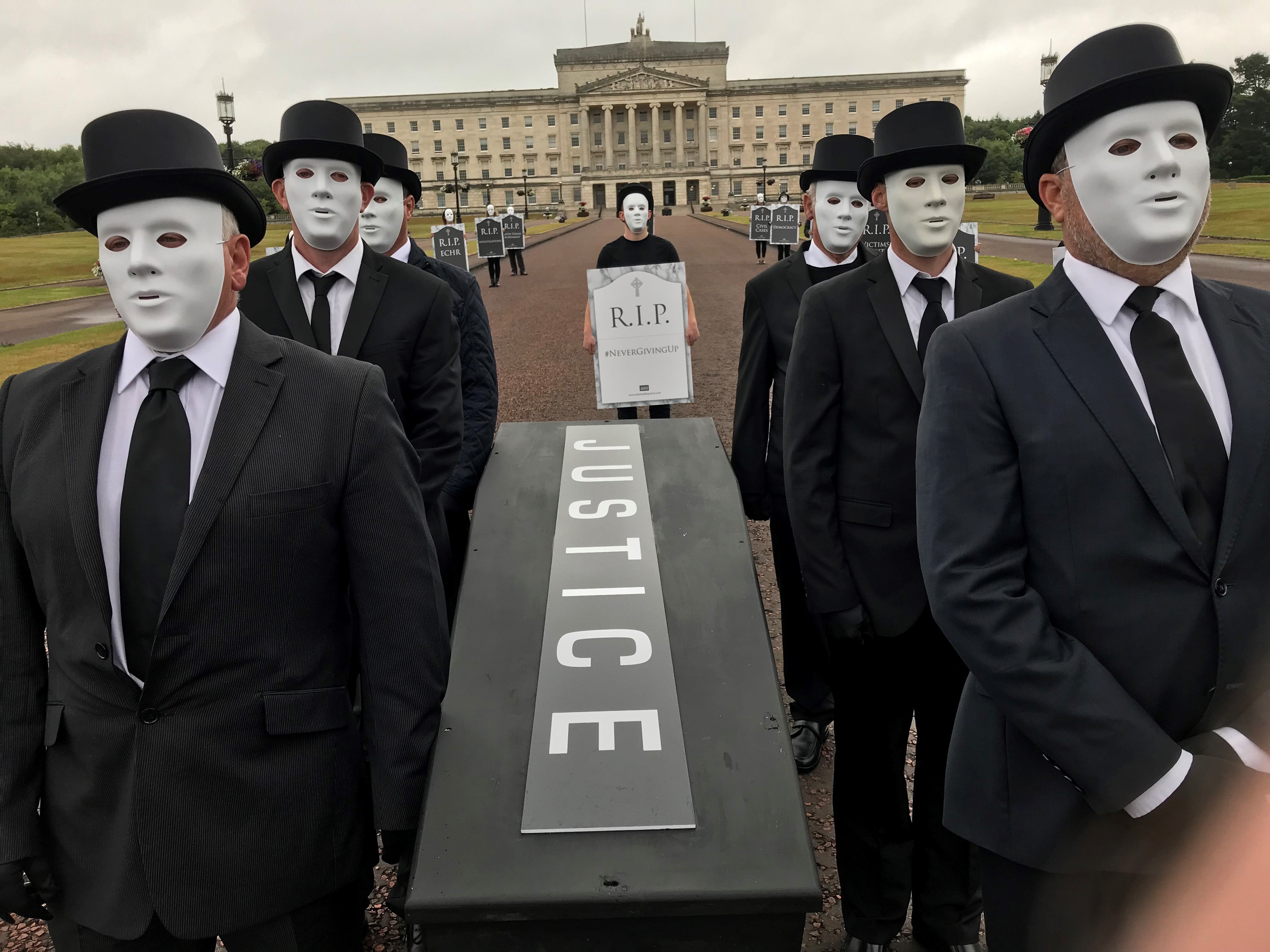 People take part in a staged funeral procession through the grounds of the Stormont estate to protest against plans unveiled by Brandon Lewis to deal with the legacy of Northern Ireland’s troubled past (Jonathan McCambridge/PA)