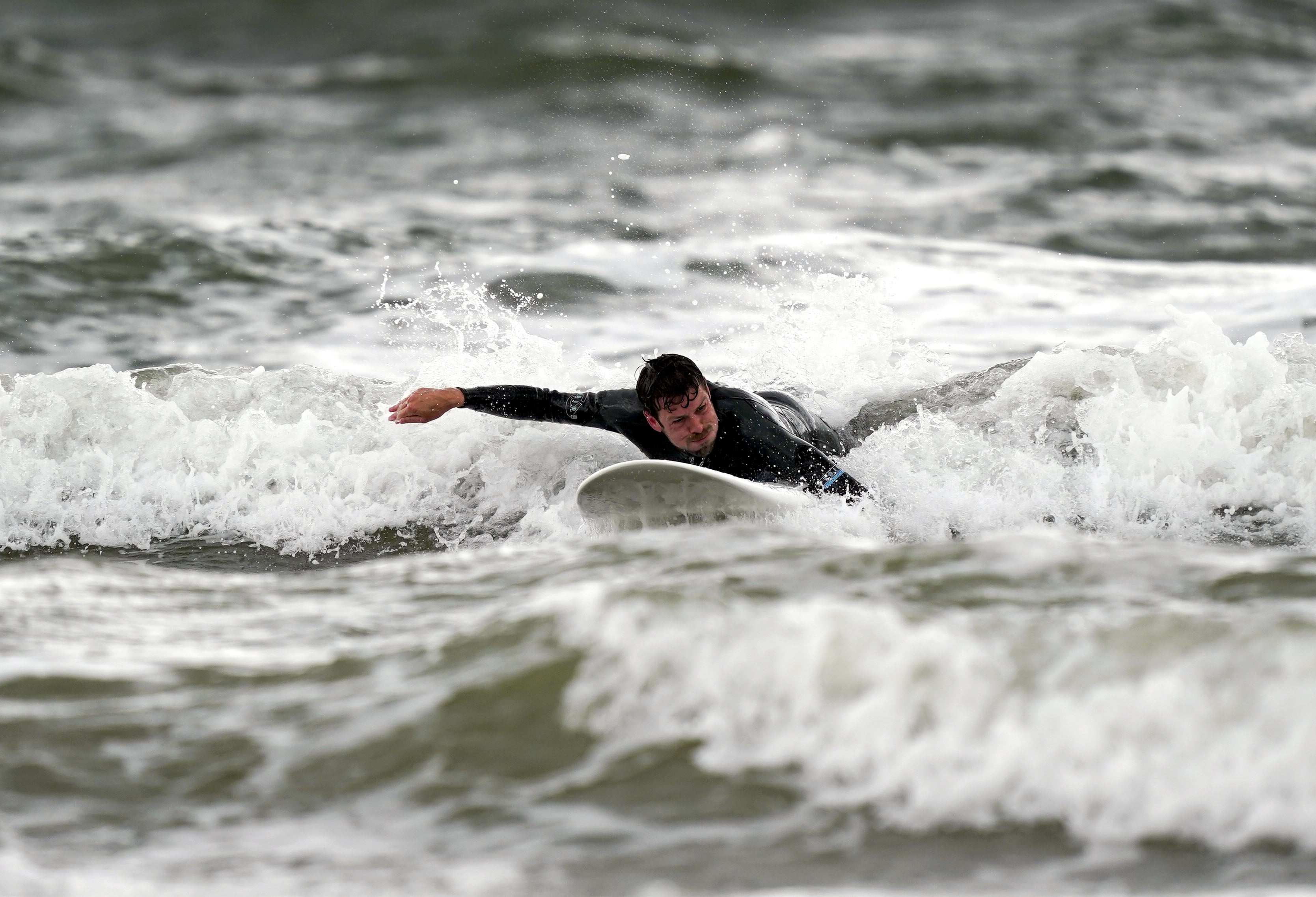 A surfer in Porthcawl (Steve Parsons/PA)