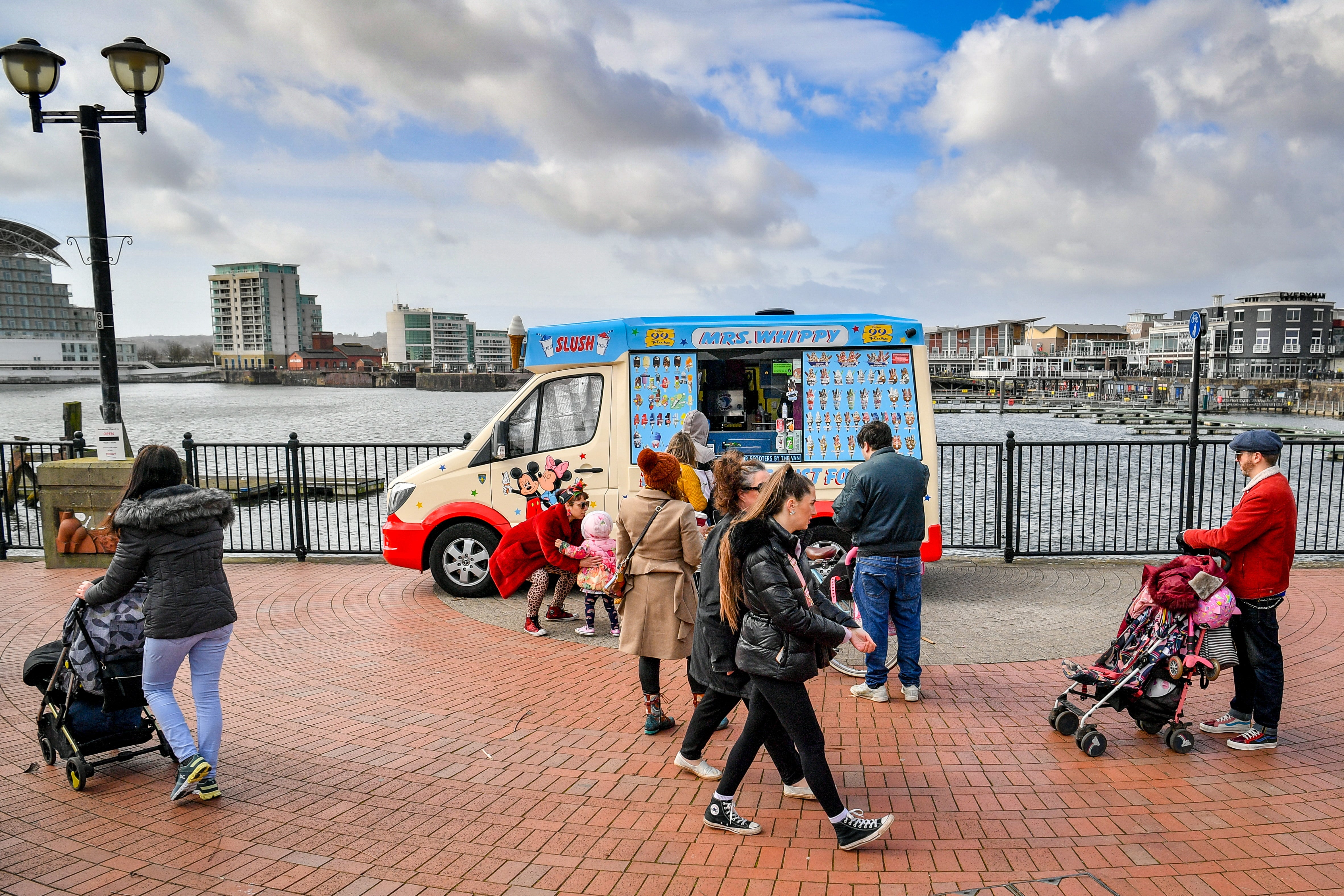 People queue for an ice-cream van in Cardiff Bay, with stay-at-home restrictions eased and people permitted to travel within their local area (Ben Birchall/PA)