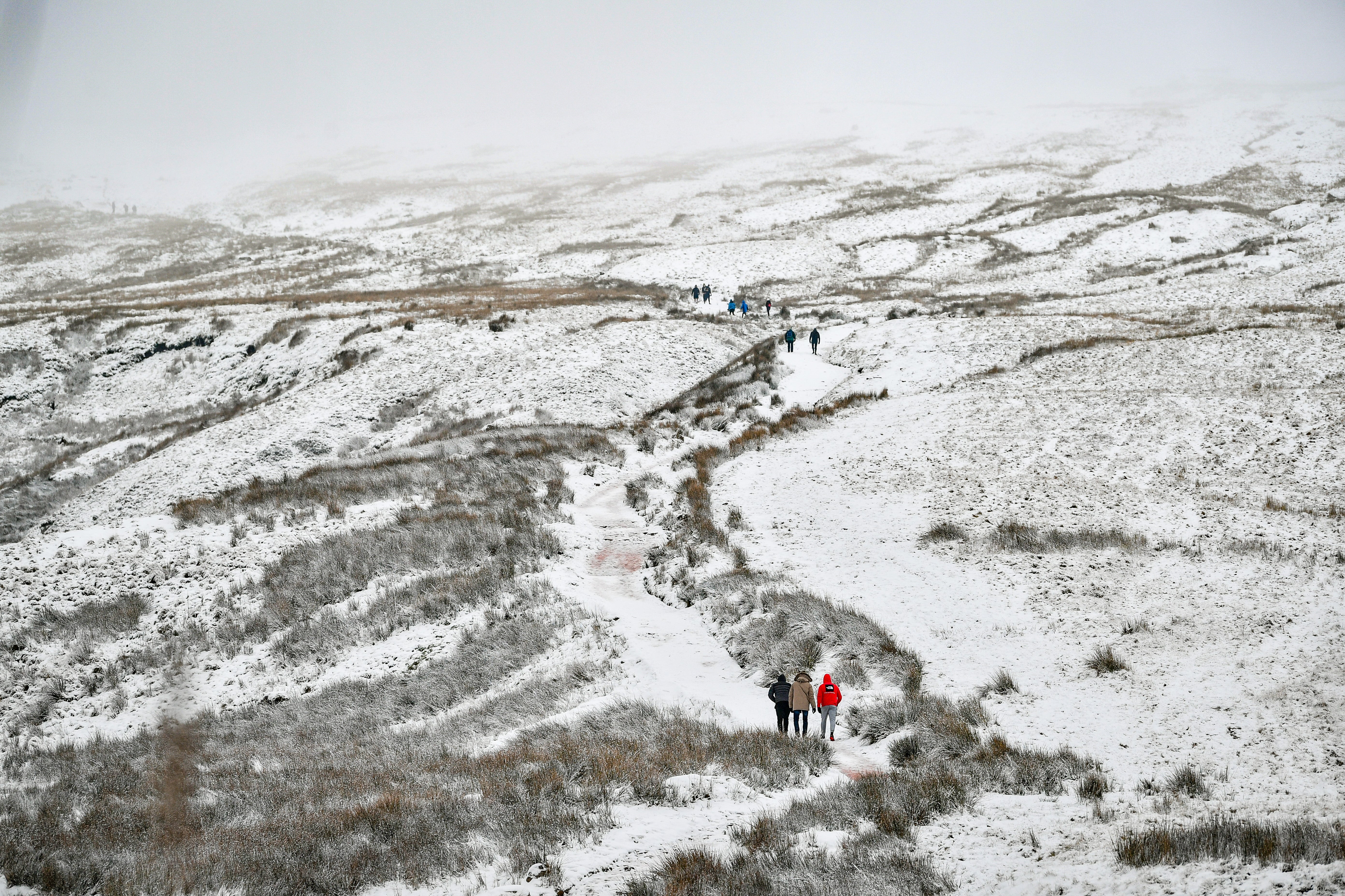 Walkers ascend the path to the summit of Pen y Fan, South Wales’s highest mountain, in snowy conditions (Ben Birchall/PA)