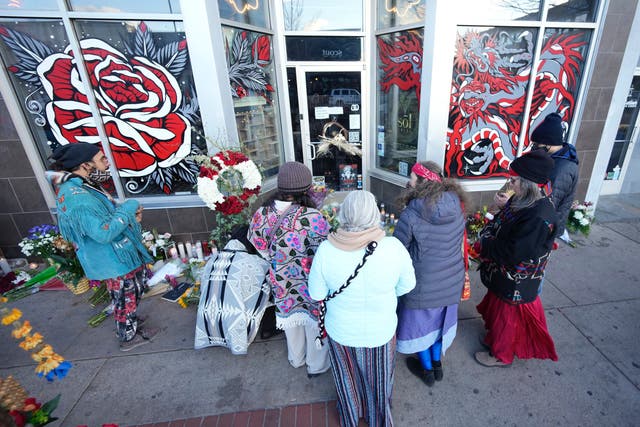 <p>Mourners gather outside a tattoo parlour along South Broadway, in Denver, Colorado</p>