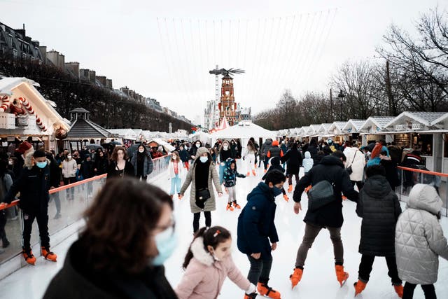 <p>People wear face masks to curb the spread of COVID-19 as they ice skate at a funfair in Paris</p>