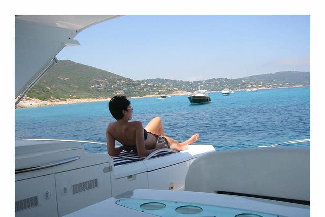 Ghislaine Maxwell sunbathes on a yacht in a photo issued by the US Department of Justice (PA)