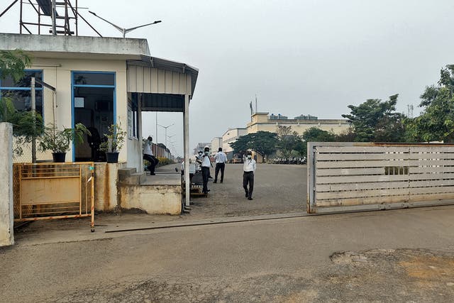 <p>Private security guards stand at the entrance of a closed plant of Foxconn India</p>