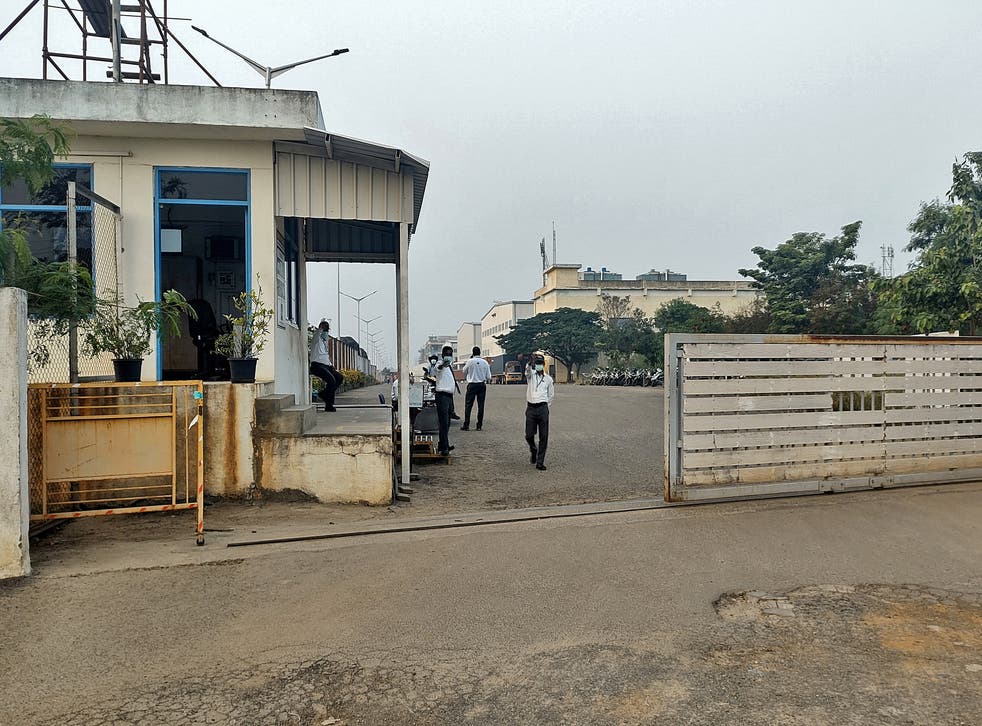 <p>Private security guards stand at the entrance of a closed plant of Foxconn India</p>