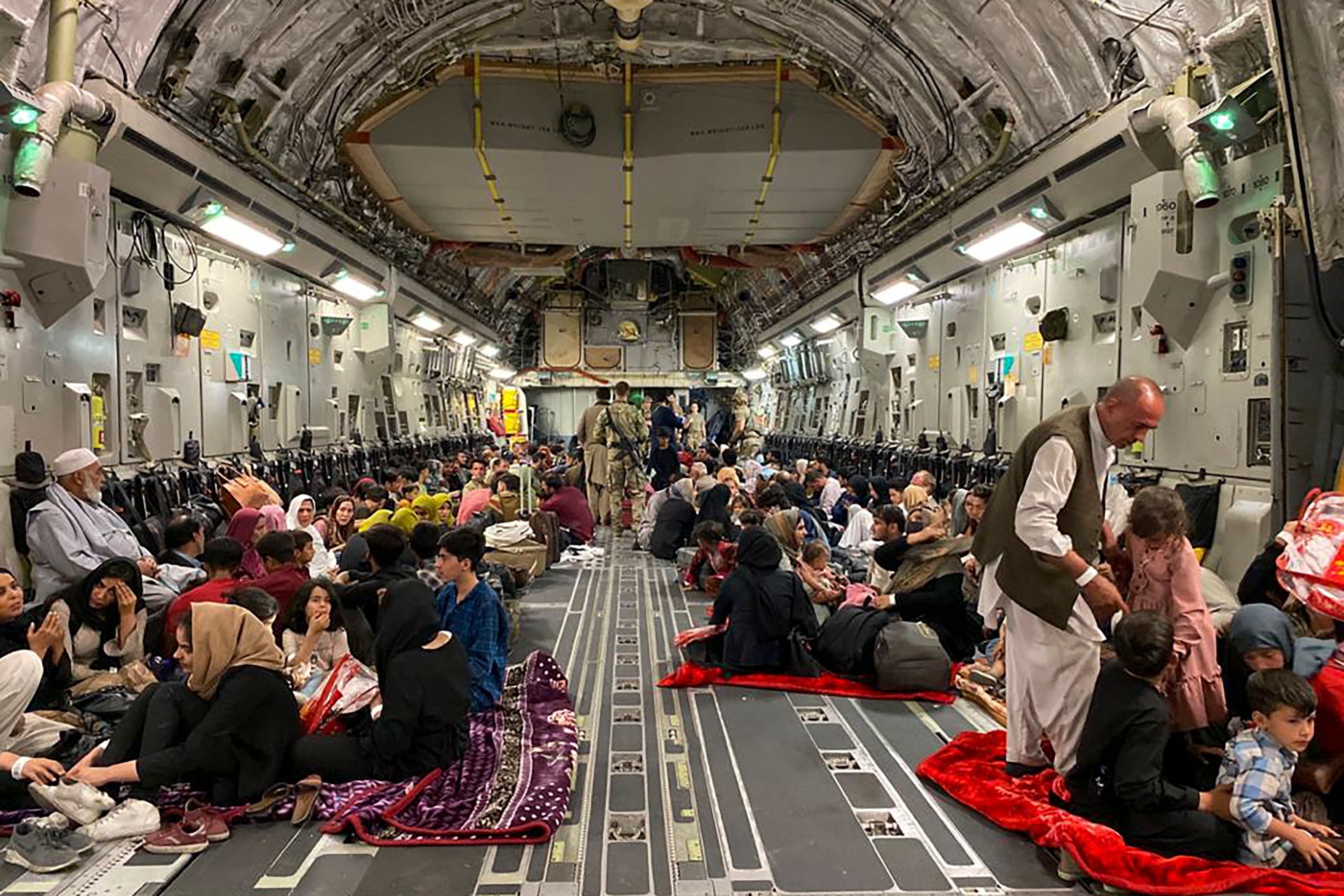 Afghan people sit inside a US military aircraft to leave Afghanistan after the Taliban takeover