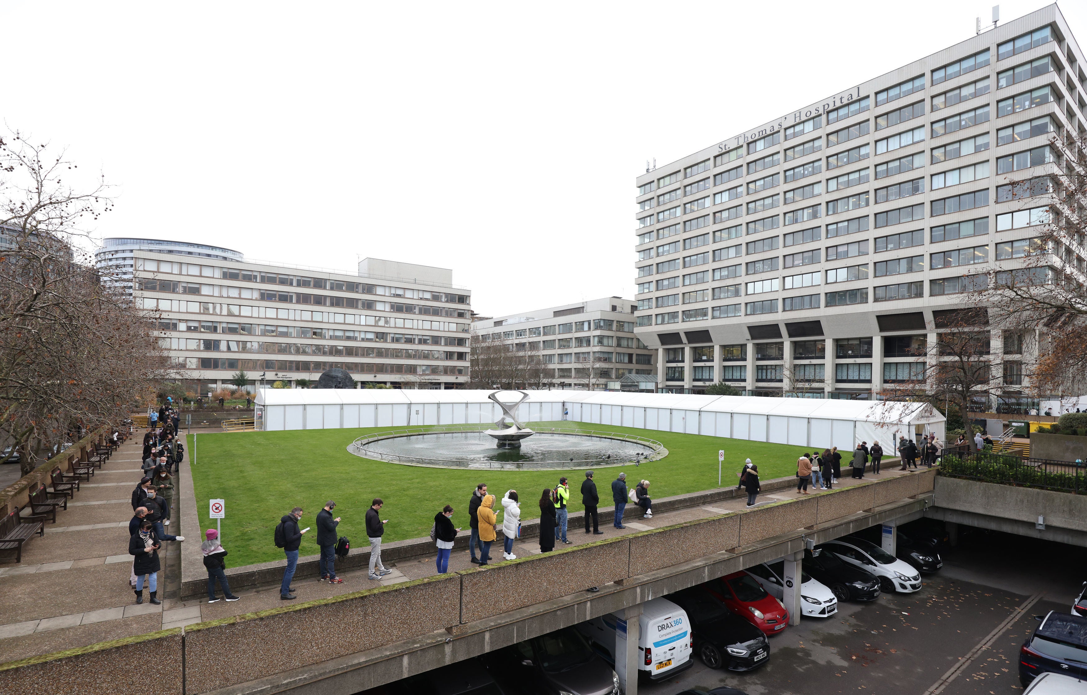 People queue at a vaccination centre at St Thomas' Hospital in London, as the coronavirus booster vaccination programme is ramped up