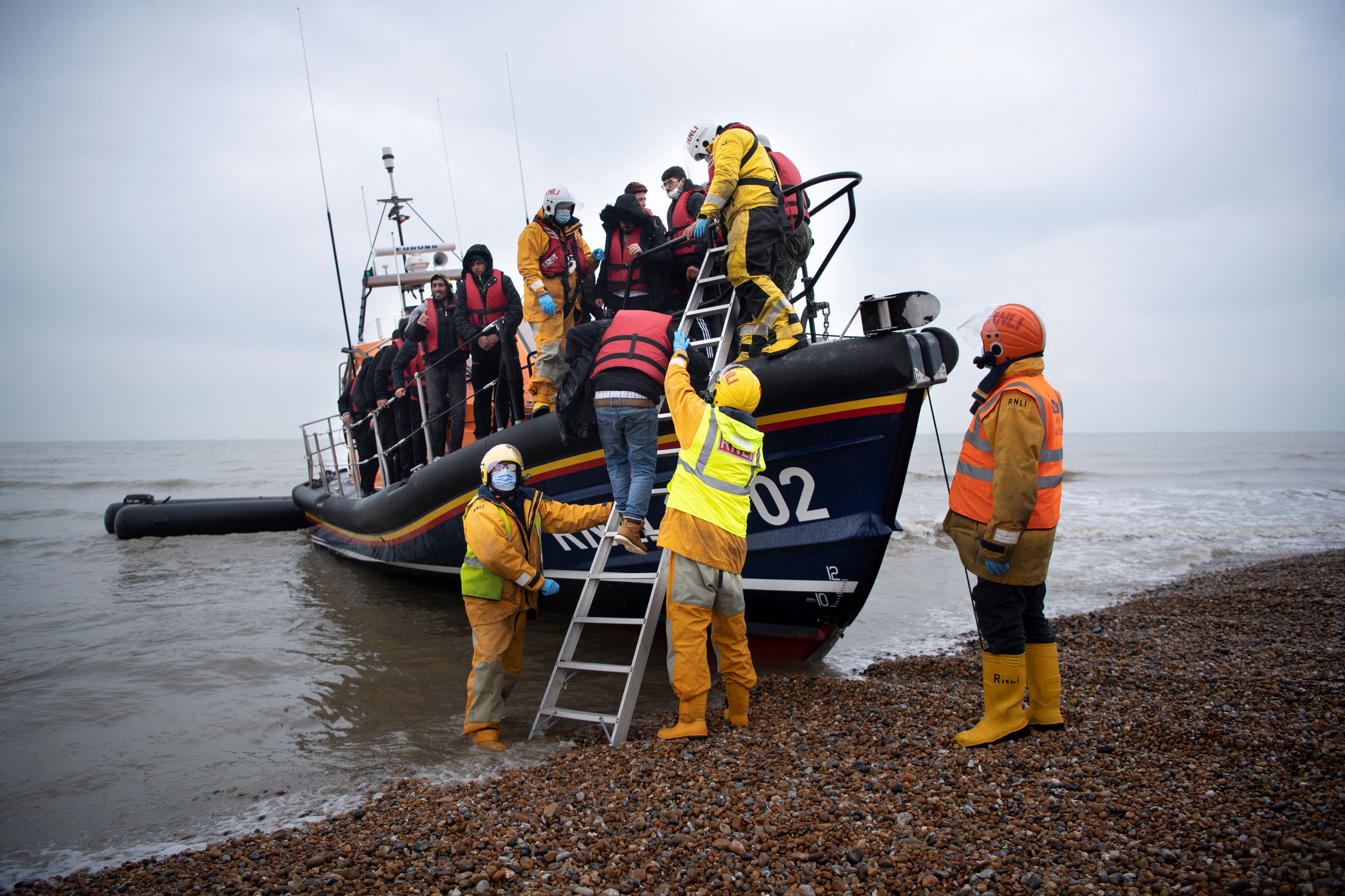 Migrants are helped ashore from an RNLI lifeboat at Dungeness, Kent