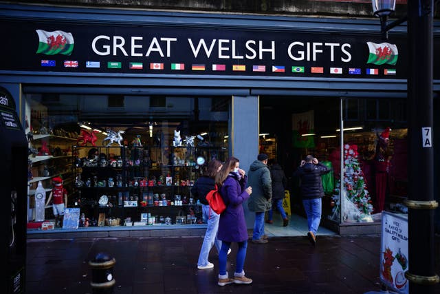 People adjust face masks as they enter the Great Welsh Gifts store in Cardiff, Wales (Ben Birchall/PA)